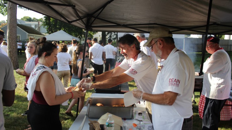 Dean College faculty and staff serving students hotdogs at the Annual Welcome Back BBQ event.