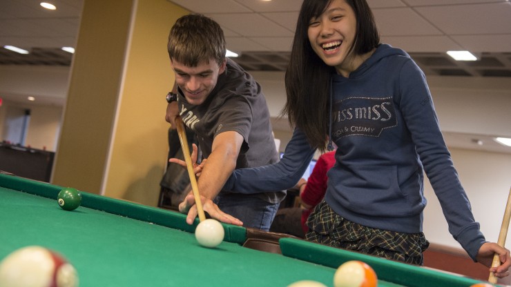 Two students playing pool in Boomer's located in the Campus Center.
