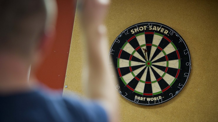 Student playing darts at Boomer's located in the Campus Center.