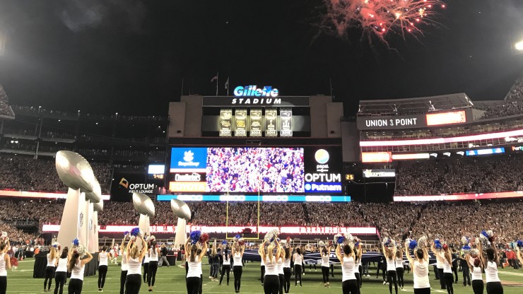 Dean College students dancing on the field at Gillette Stadium during a performance at a New England Patriots game.