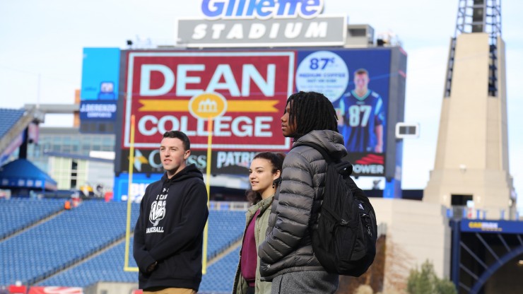Three students on the field at Gillette Stadium. 