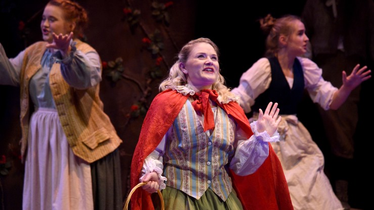 Multiple students singing during a scene from the Into The Woods performance.