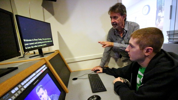 Professor helping a student in the production control room on the set of Dean Today, a college news show. 