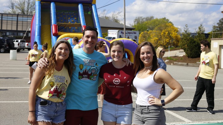 Group of students and staff at the Spring Fling carnival event outside of Dean Hall. 