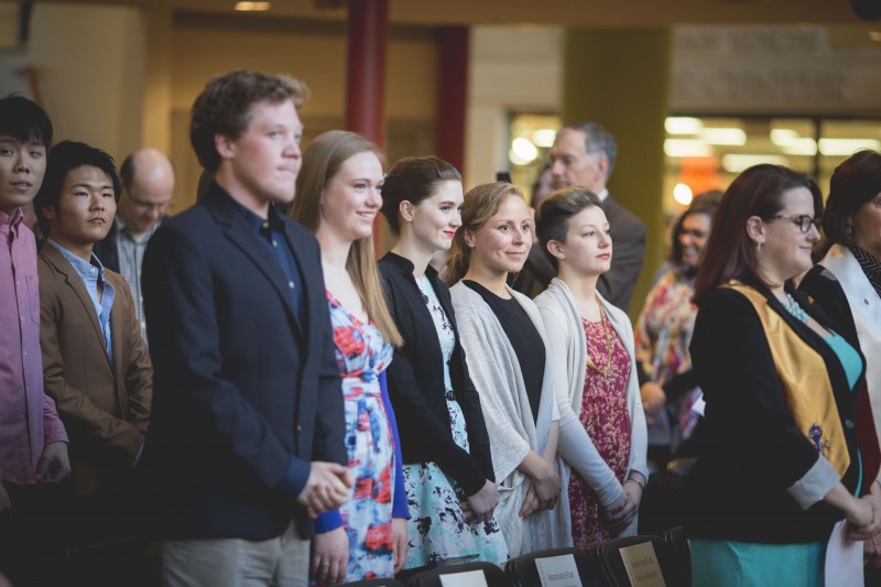 image of students standing, facing the podium during leadership conference